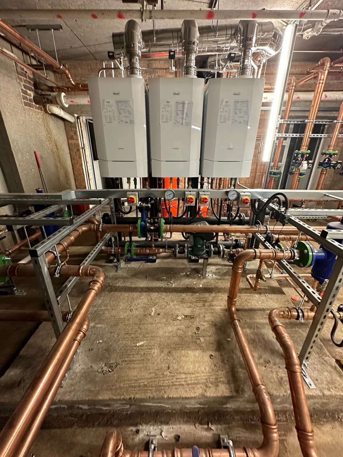 Commercial plant room with boiler cascade, pumps and coordinated copper pipework