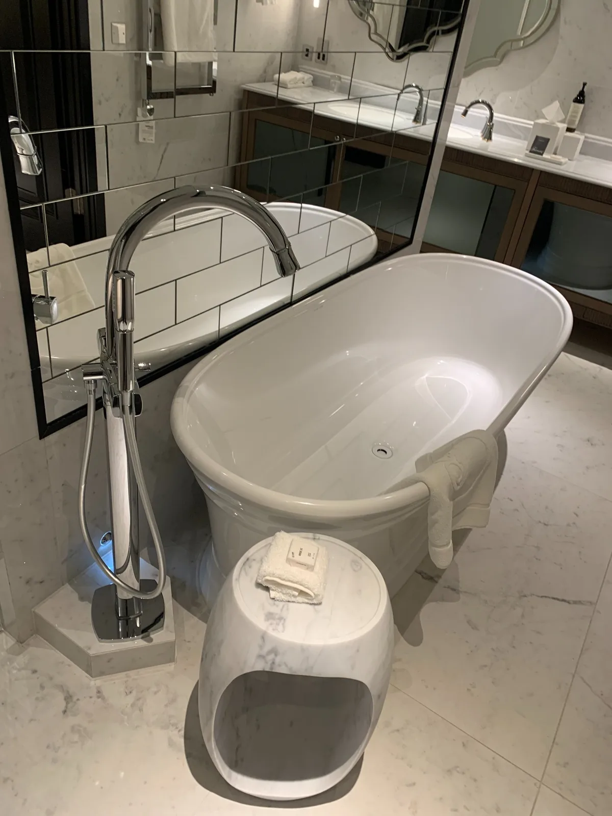 Luxury hotel bathroom with freestanding bath and marble-effect finishes